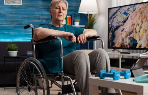 disability-senior-woman-wheelchair-looking-gymnastic-online-video-tablet-computer