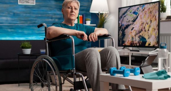 disability-senior-woman-wheelchair-looking-gymnastic-online-video-tablet-computer